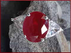 Detailabbildung: Ring mit 2 Diamanten im Triangelschliff, zus. 1,4 ct, und einem ovalen Rubin, 5,05 ct. 18