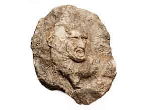 Detailabbildung:  Flachrelief in kristallinem Stein mit herausgemeißeltem Kopf eines Mannes mit kämpferischer Mimik und weit aufgerissenem Mund