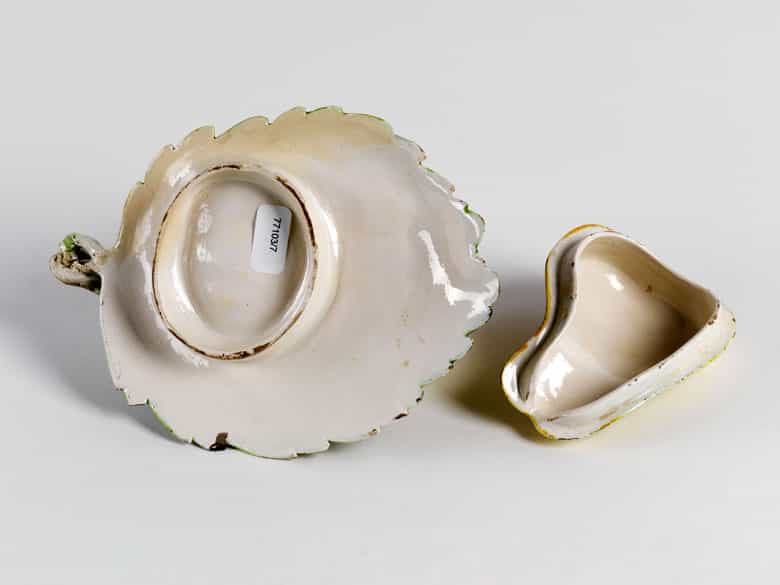 Detailabbildung: Fayence-Deckeldose in Form einer Birne auf einem großen Feigenblatt liegend