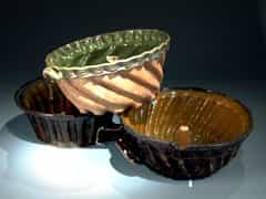 Drei Keramik-Gugelhupfformen, z.T. altrepariert, braun und grün glasiert, 19. Jhdt.