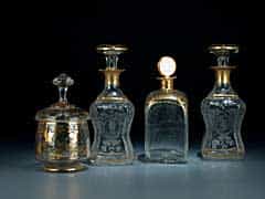 Konvolut von drei Glasflaschen und einer Deckeldose mit Golddekor