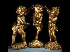 Gruppe von drei geschnitzten, gefassten und vergoldeten Puttenfiguren