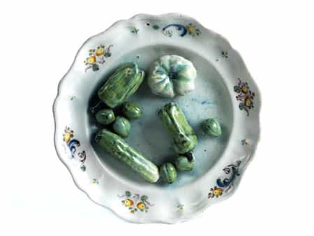 Fayence-Schaugerichtteller mit eingelegtem Gemüse wie Gurken, Paprika und grünen Tomaten
