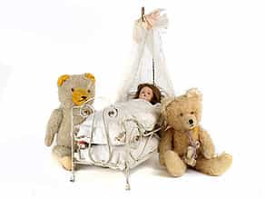 Puppenbett mit Puppe und zwei Teddys
