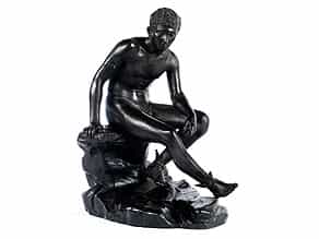 † Bronzefigur des jugendlichen, auf einem Felsblock sitzenden Gottes Hermes